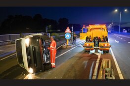 Bestelbus ramt betonblok en belandt op zijkant op N235