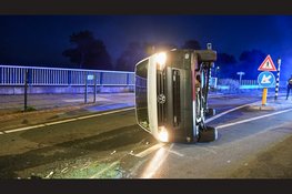Bestelbus ramt betonblok en belandt op zijkant op N235