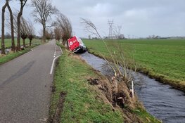 Pakketbezorger in de sloot door storm